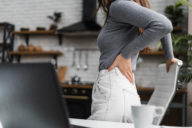 side view woman having backache while working from home 23 2148813149