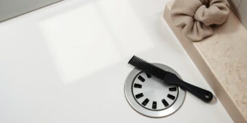 چند تار مو کنار کف‌شور حمام، شانه و کش پارچه‌ای روی لبه سنگی